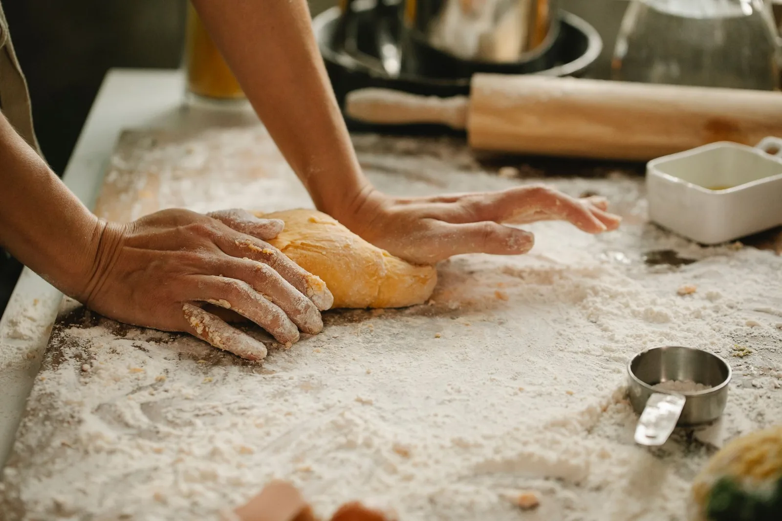 A baker working dough by hand in the bakery