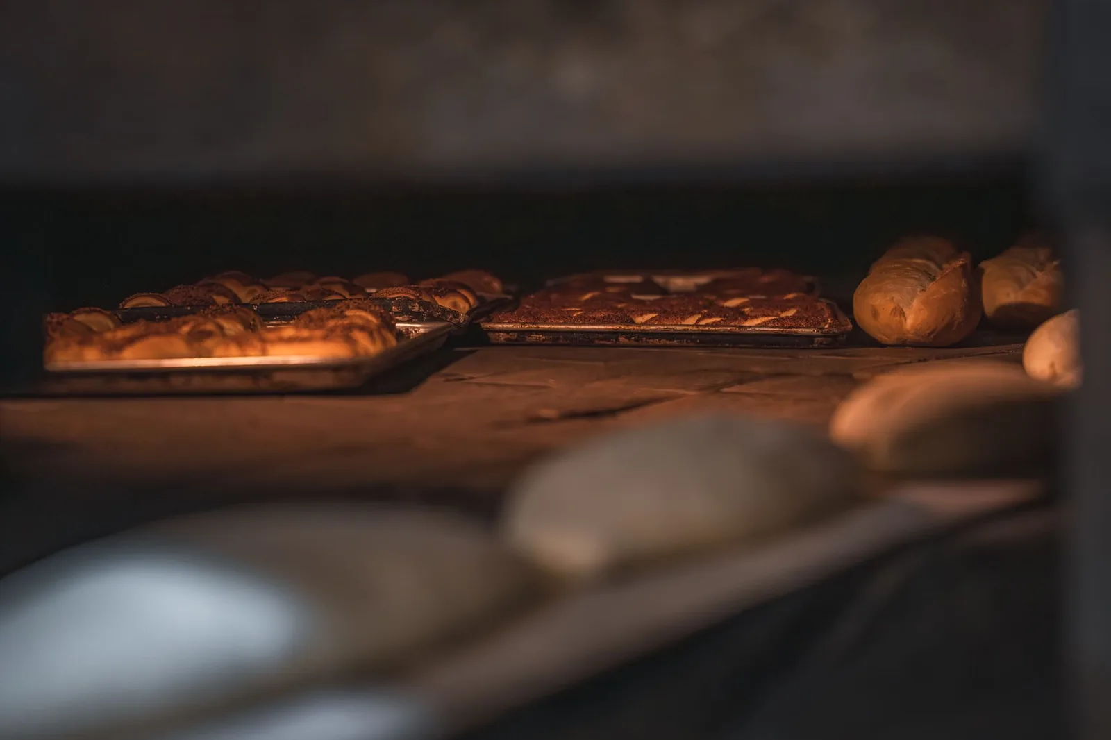 Fresh artisan bread loaves on a wooden bakery counter