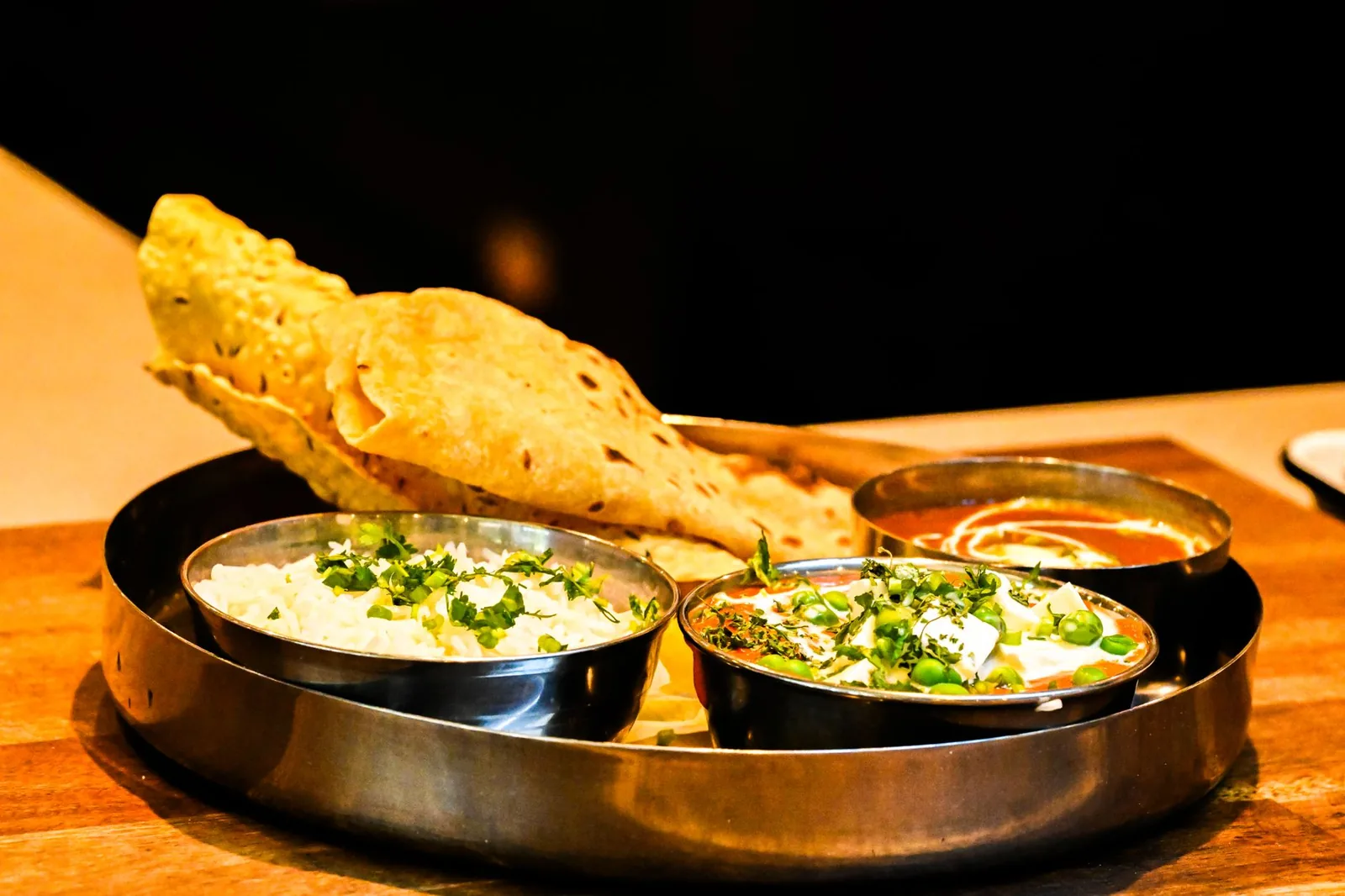 A rich Banarasi vegetarian thali served on a brass plate