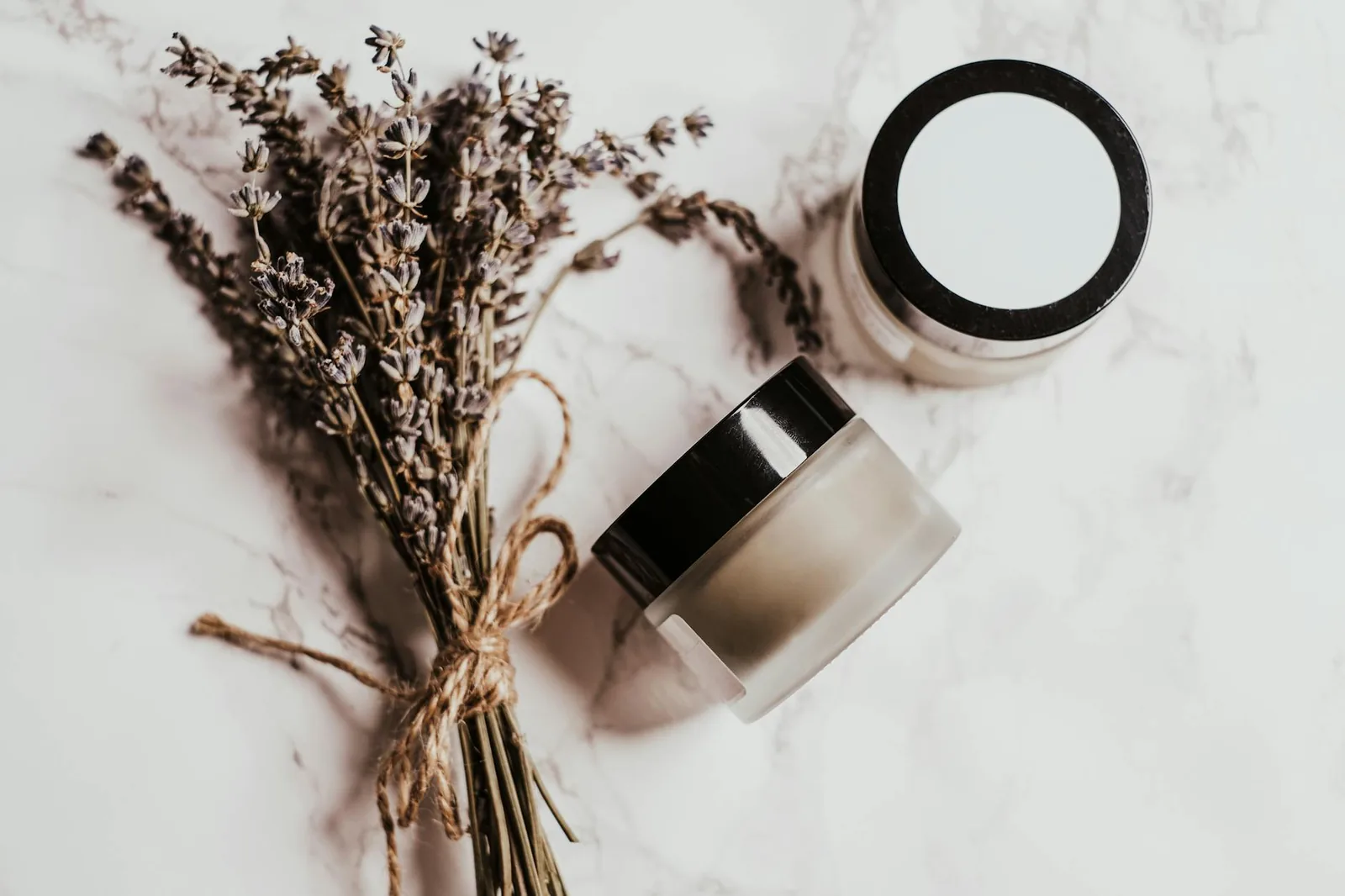 Natural herbal skincare products and botanical ingredients arranged on a warm earthy surface