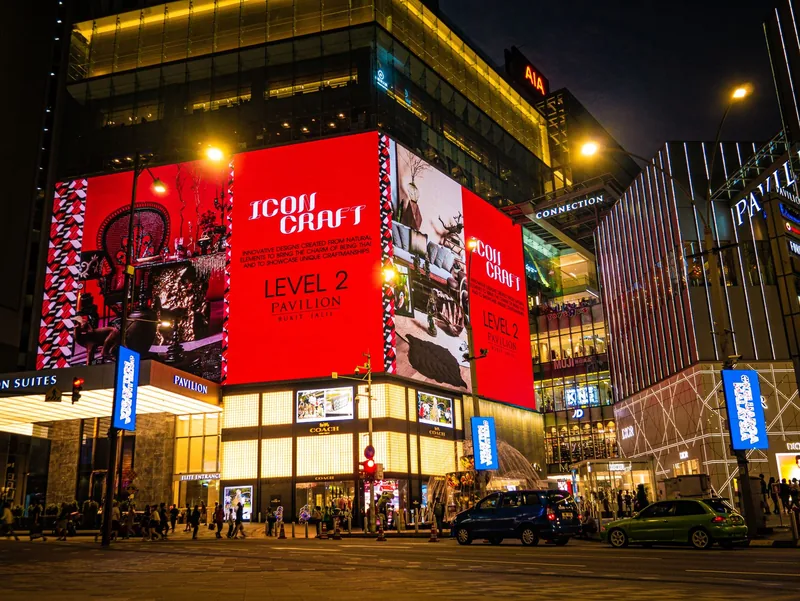 High-rise buildings and lit screens across a city at night