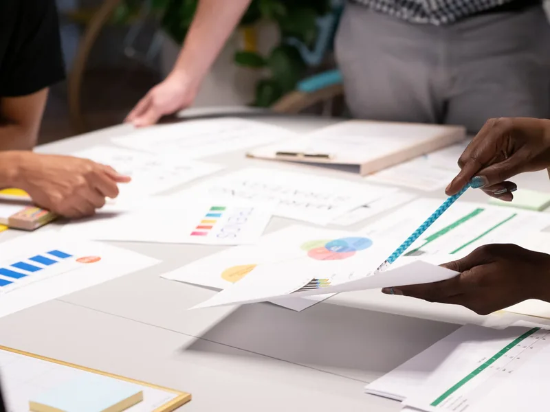 Marketing team reviewing campaign plans and documents at a desk