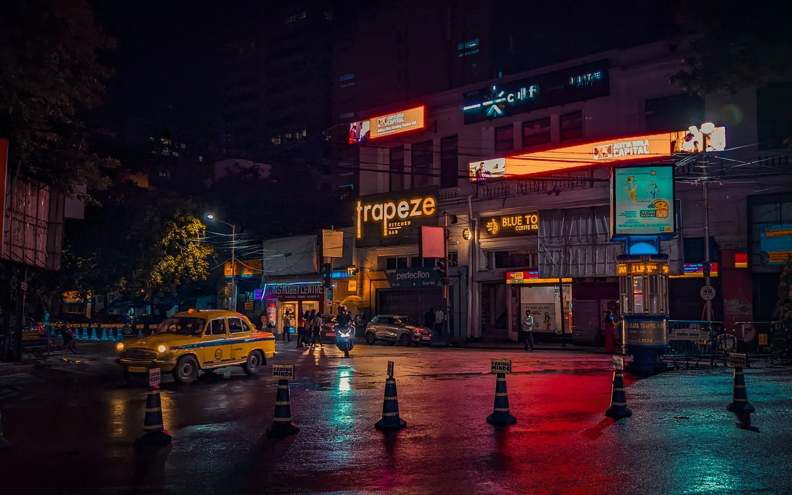 Busy Indian city street at night lit by traffic and shop signage