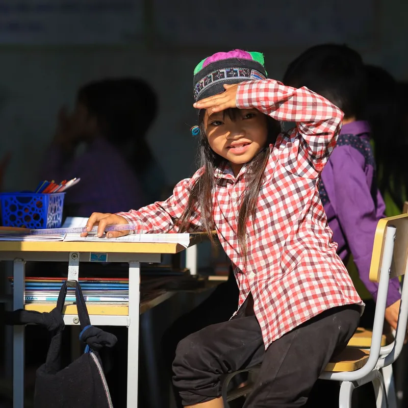 School children seated at their desks with books and materials