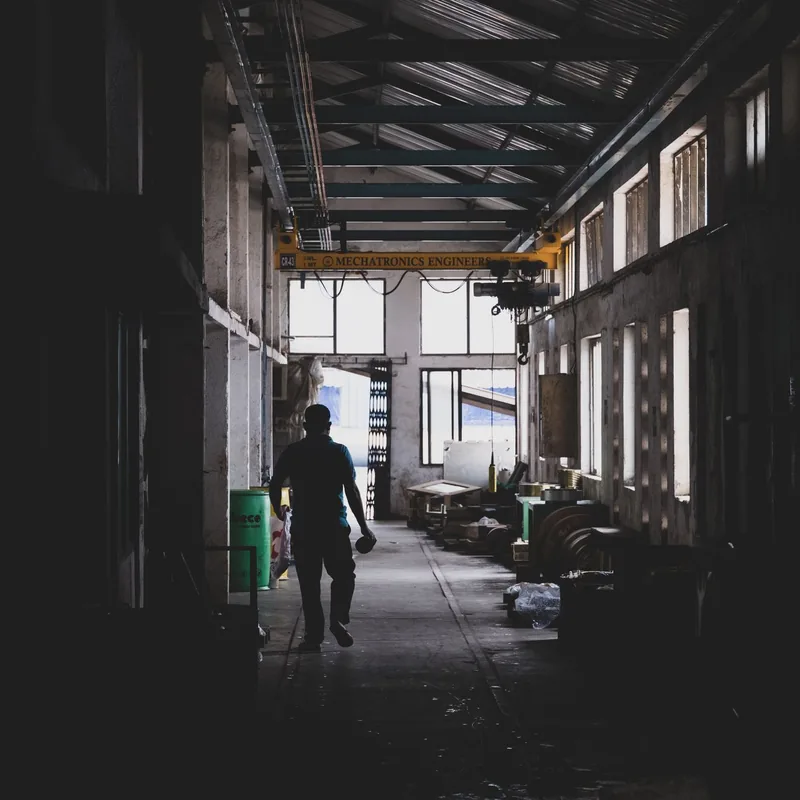 A worker walking through an Indian manufacturing workshop where training reaches the floor