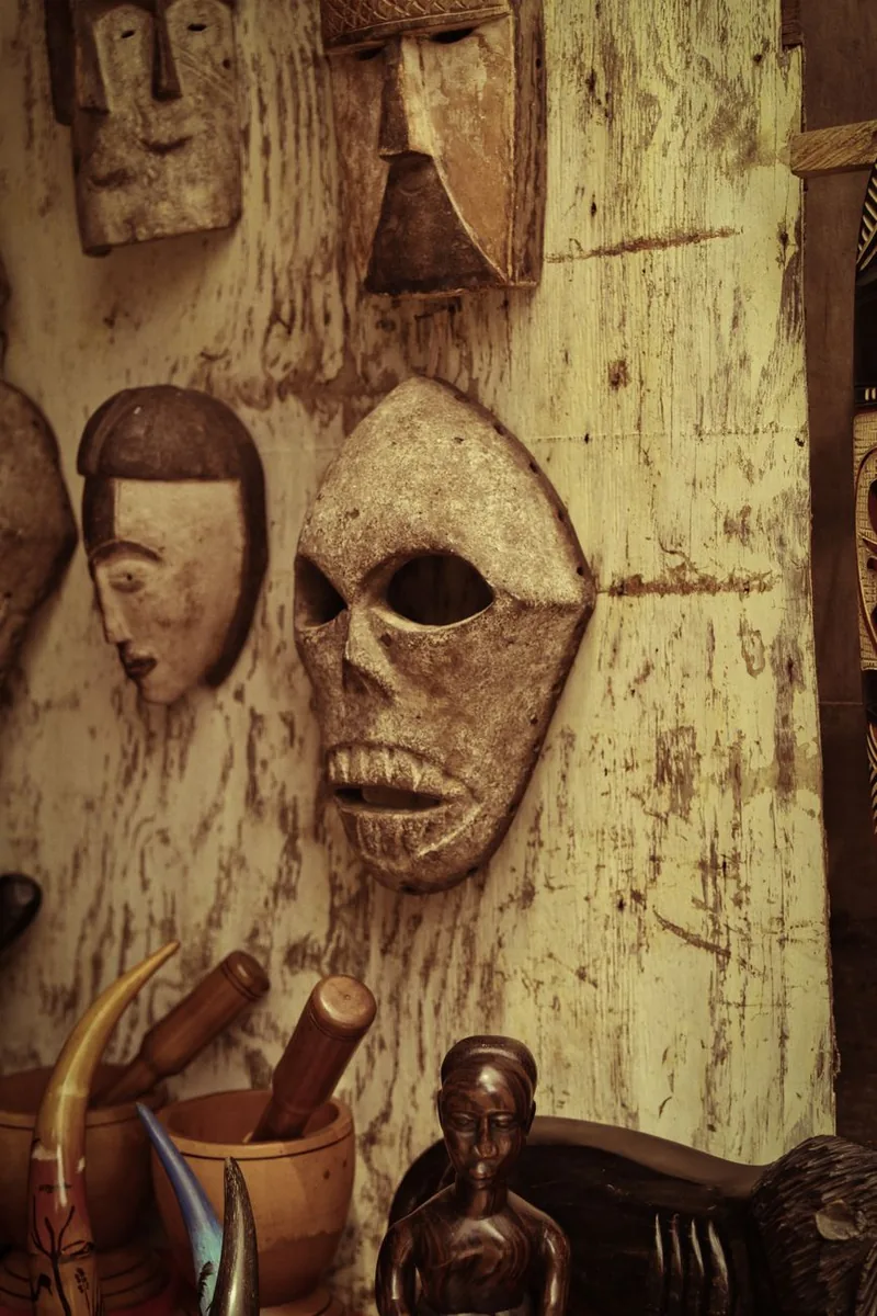 Hand-carved African wooden masks displayed on a wall