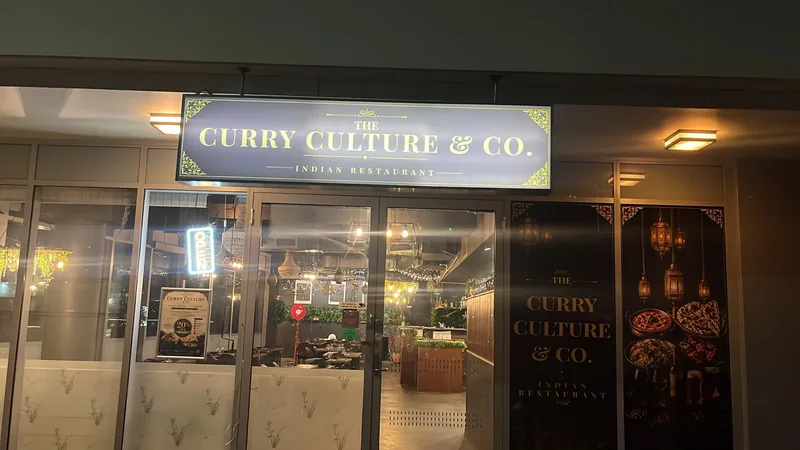 The illuminated Curry Culture & Co shopfront sign at the restaurant entrance