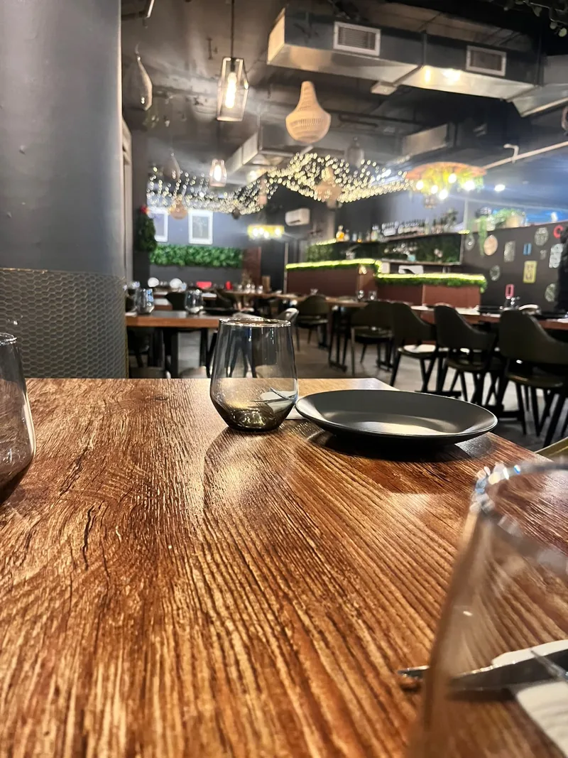 A set table with a tumbler and plate in the softly lit bar and dining area