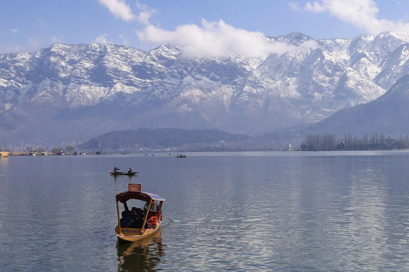 Shikara boats on Dal Lake with snow-capped Himalayan mountains, Kashmir